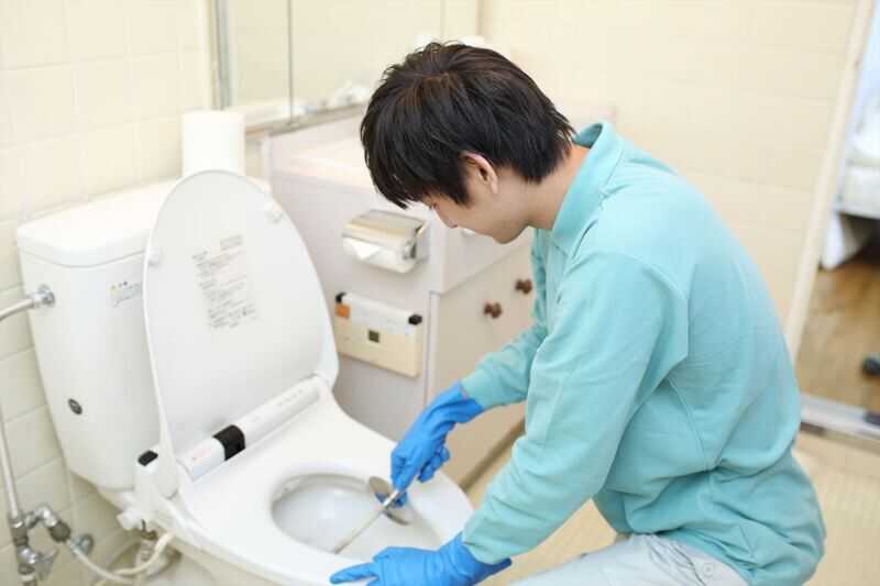 トイレ掃除を行うスタッフ